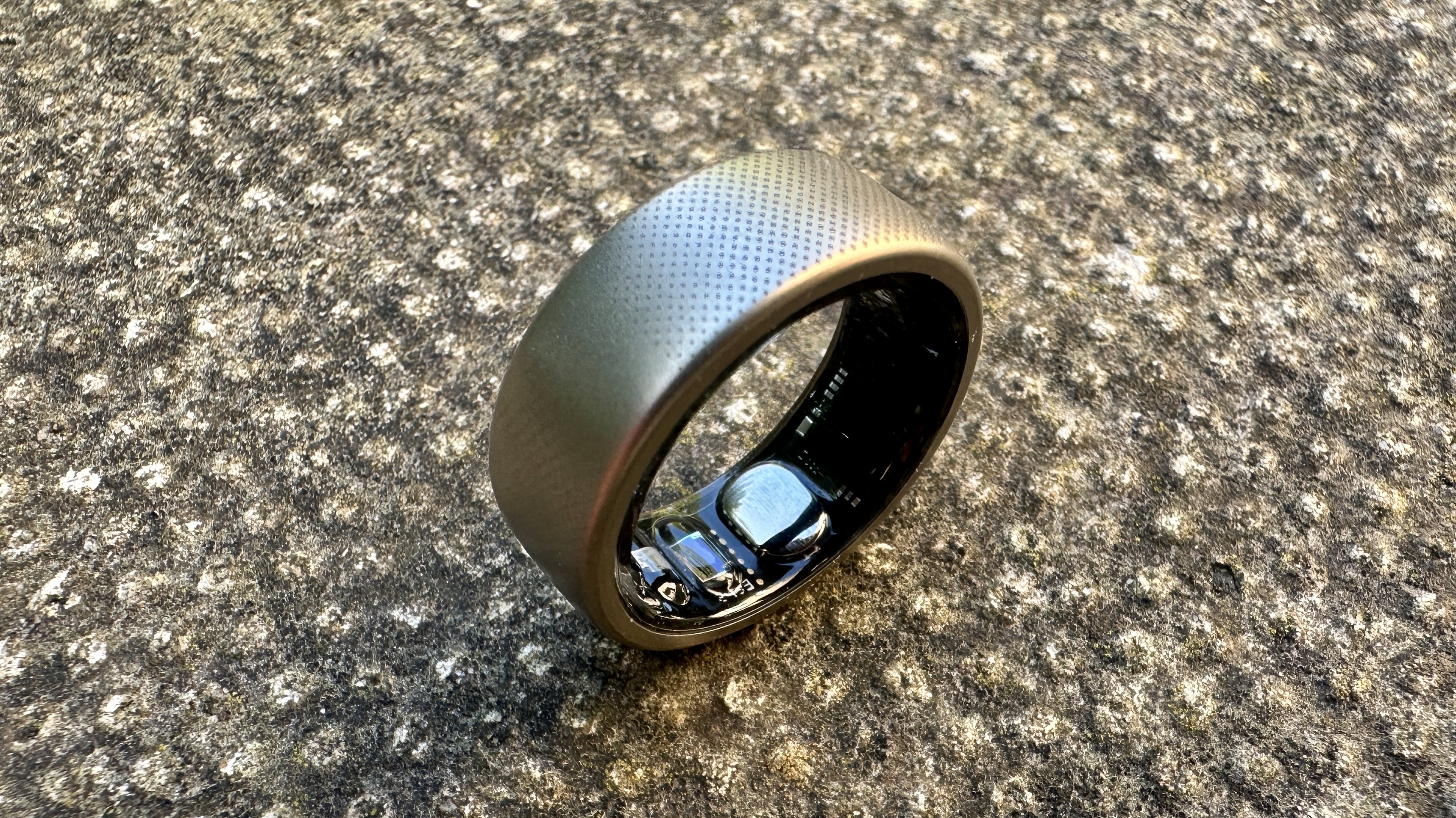 The Amazfit Helio smart ring pictured on a concrete surface.