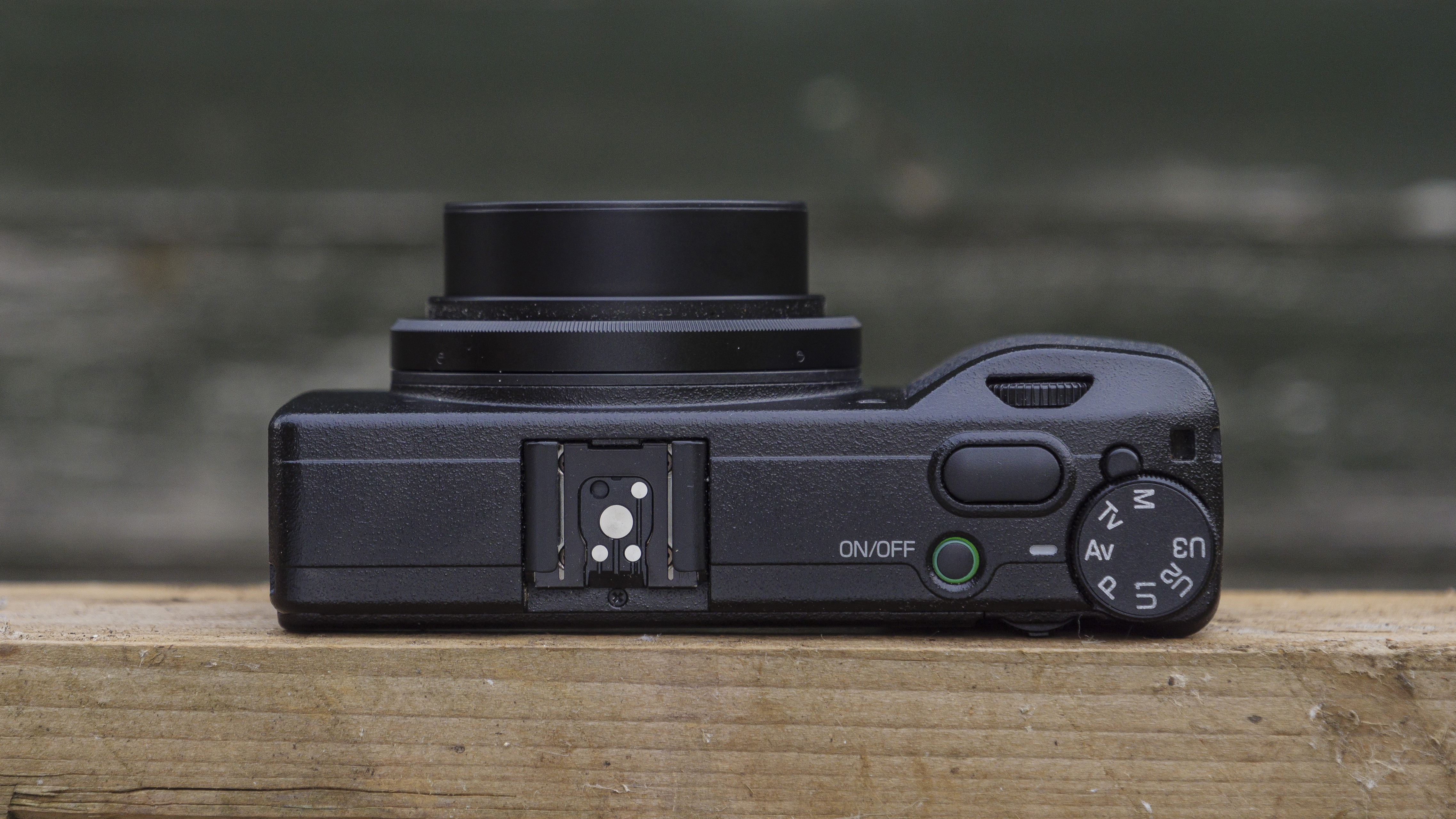 The Ricoh GR IIIx camera on a wooden table