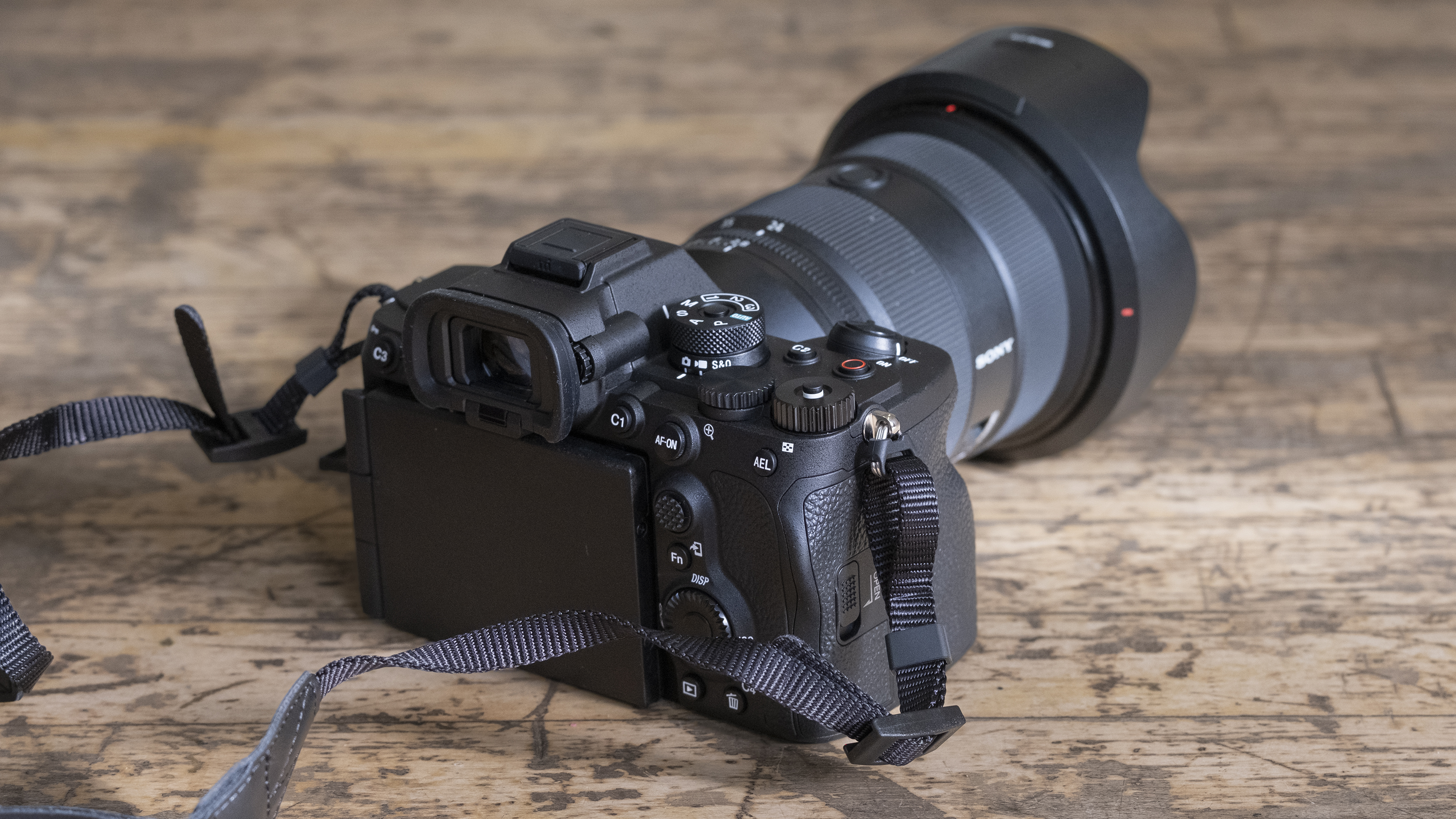 The Sony A7R V camera sitting on a wooden floor