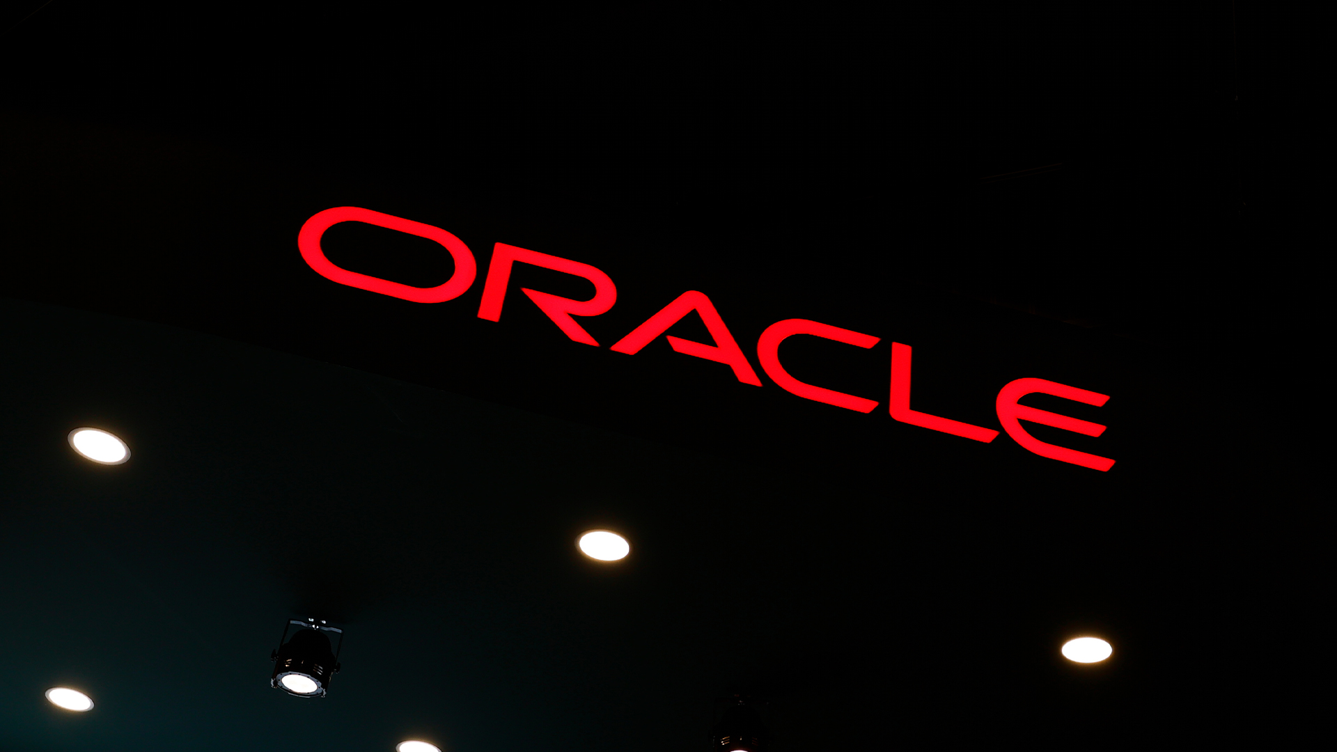 Oracle logo pictured in red lettering against a black background at the company's stall at Mobile World Congress (MWC) 2025 in Barcelona, Spain.