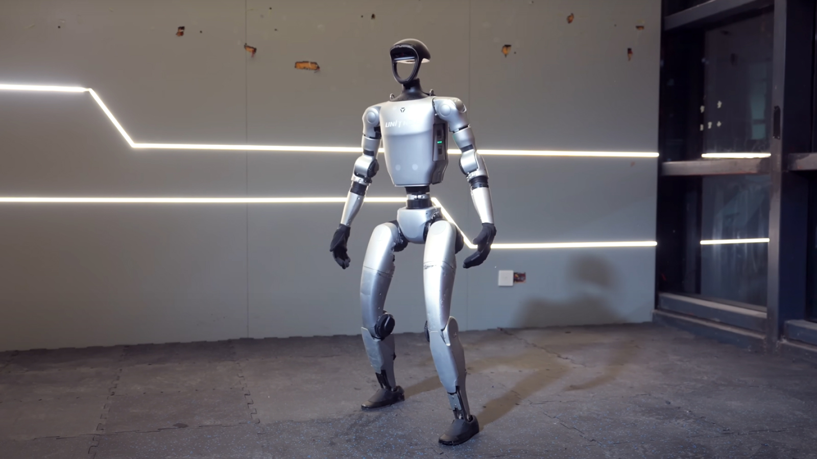 Humanoid robot stands in the center of a room.
