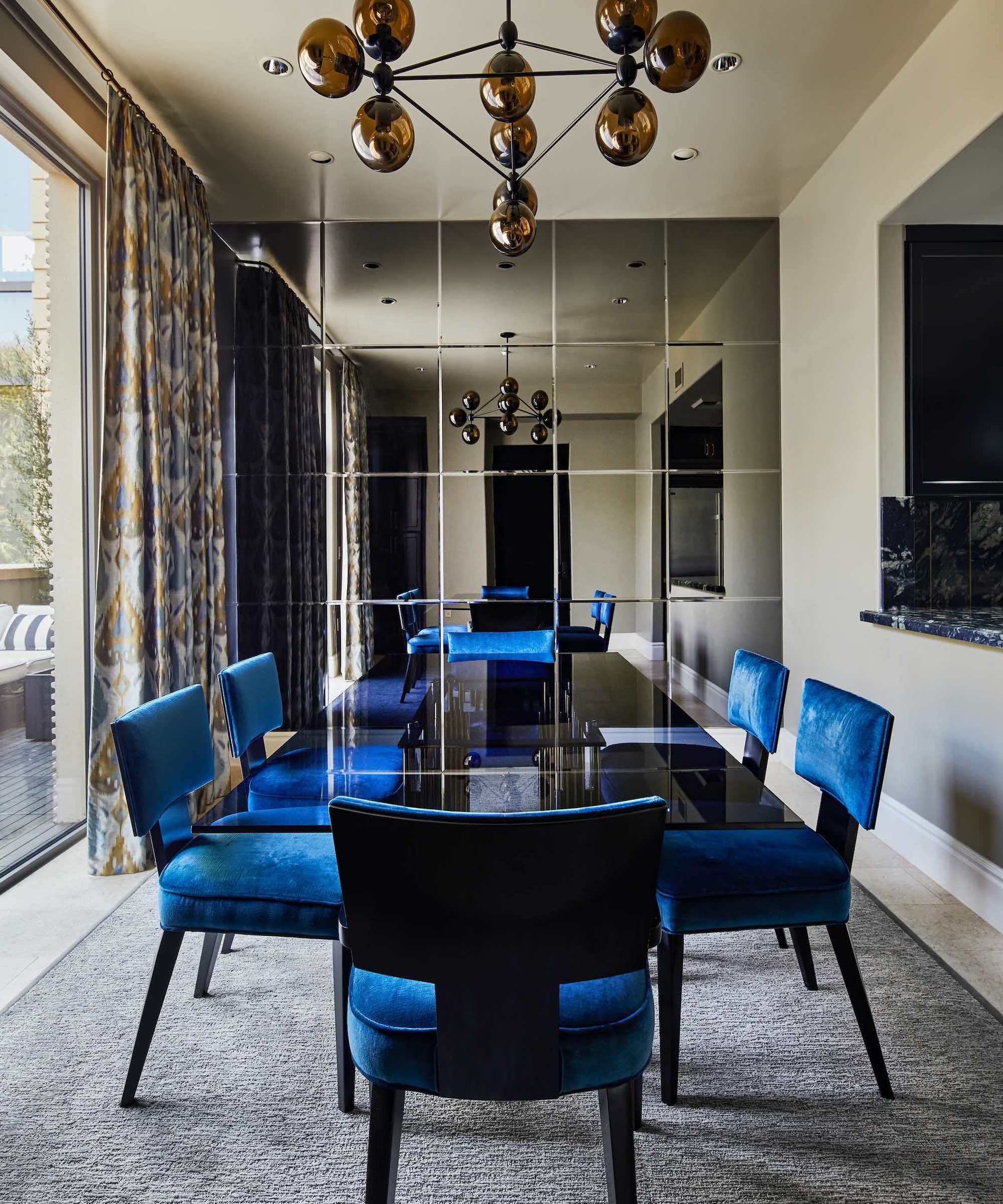 dining room with blue chairs and smoked glass table and feature wall grey rug