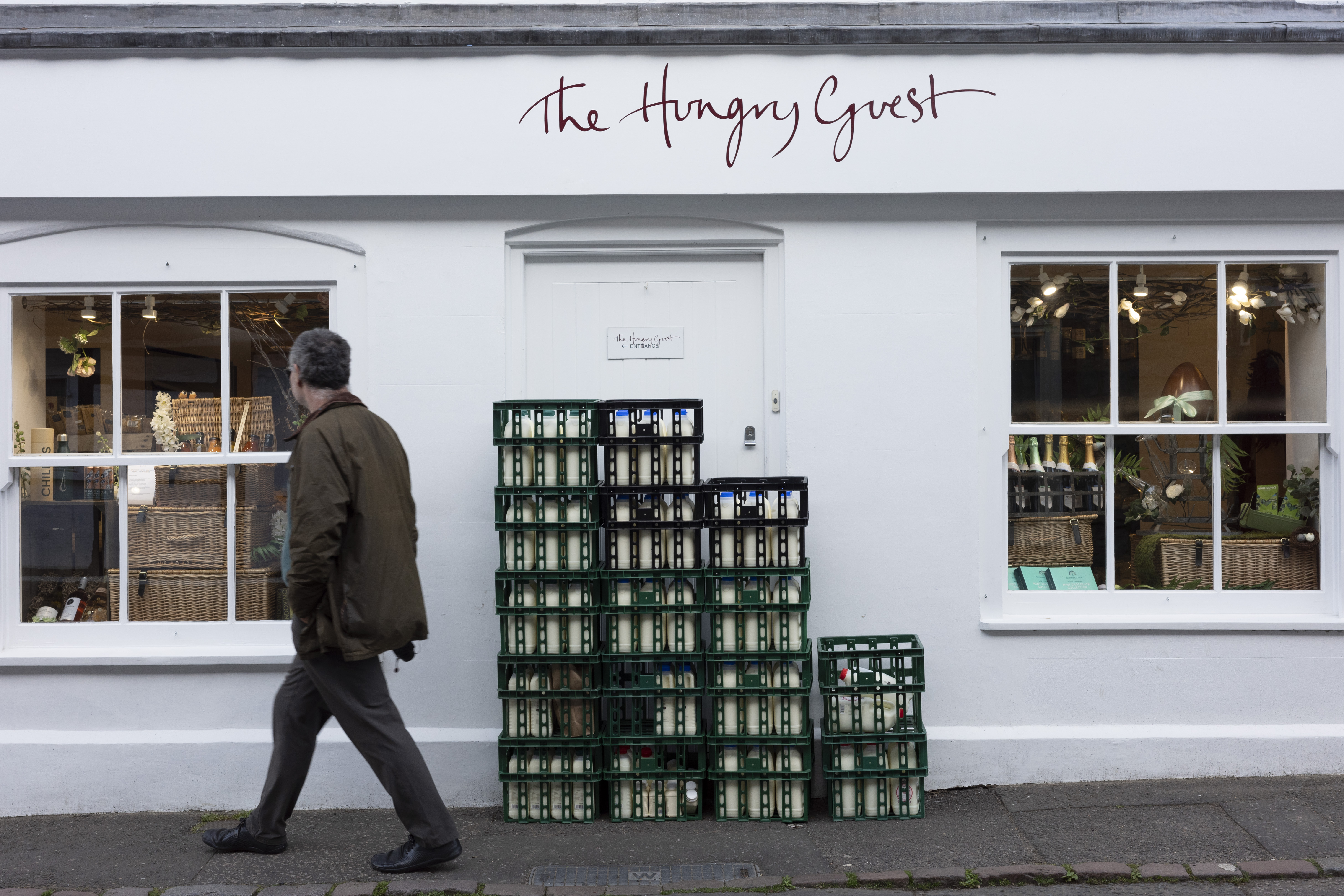 A man walking away from crates stacked outside a restaurant