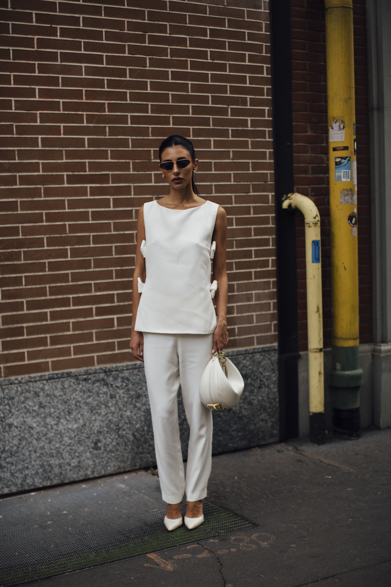 woman wearing white top, white trousers, and white heels