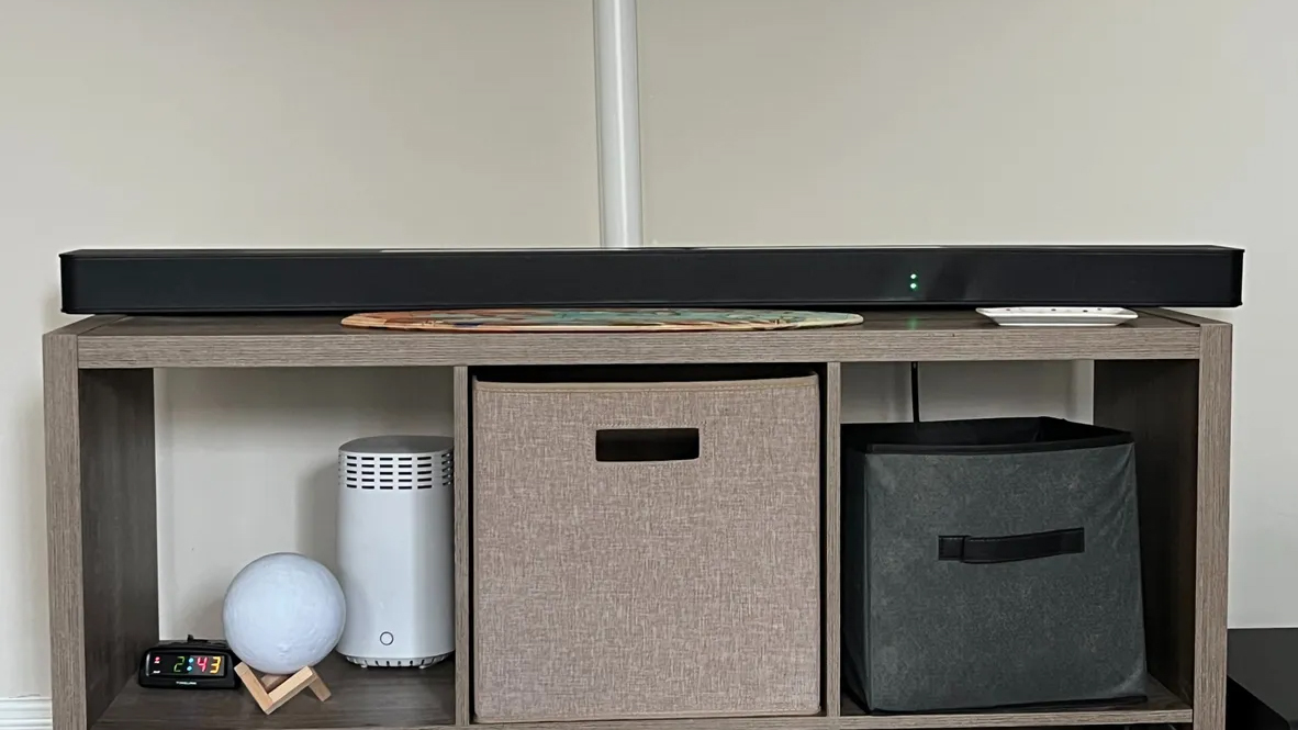LG S95TR-soundbaren placerad på en låg hylla.