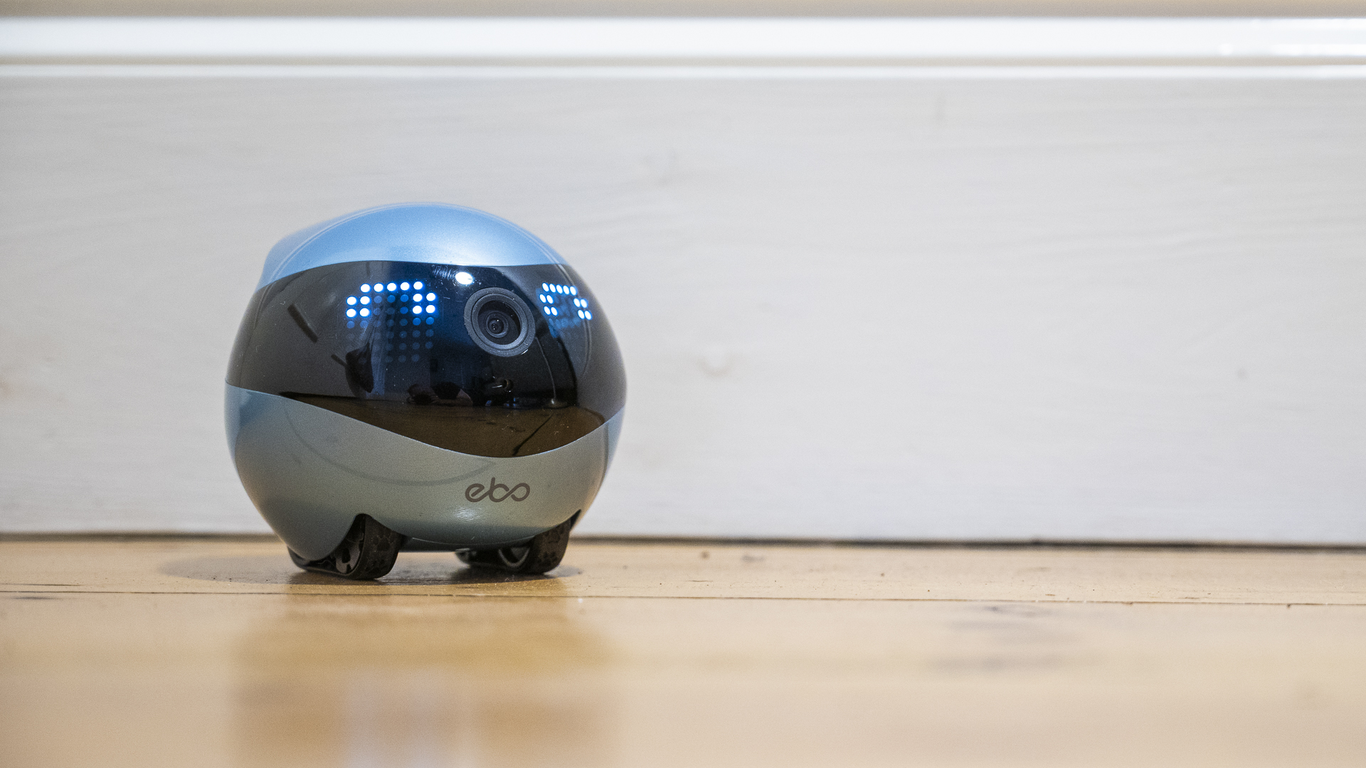 Enabot Ebo Air 2 on a wooden floor with a white skirting board behind