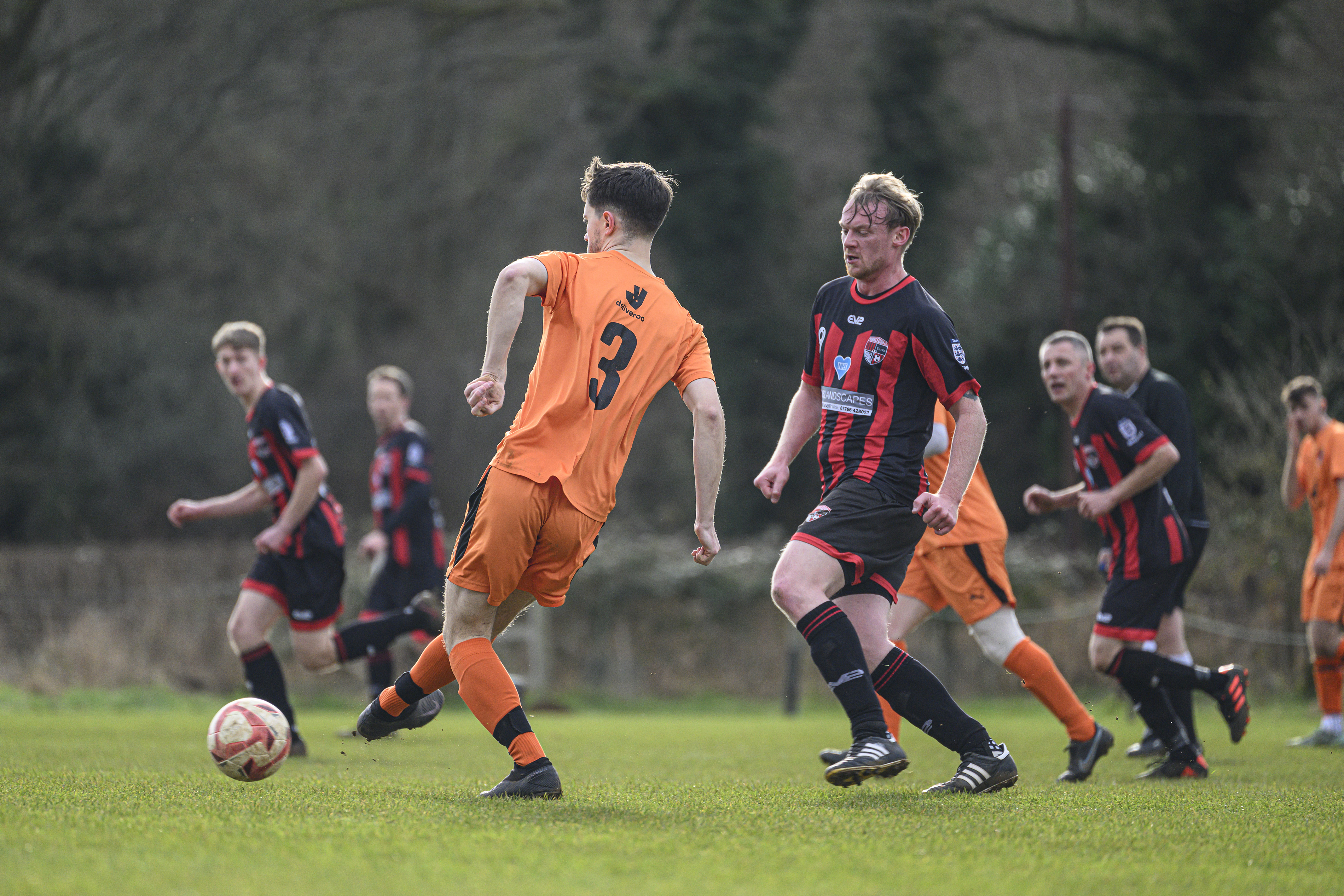 Some footballers playing in a field
