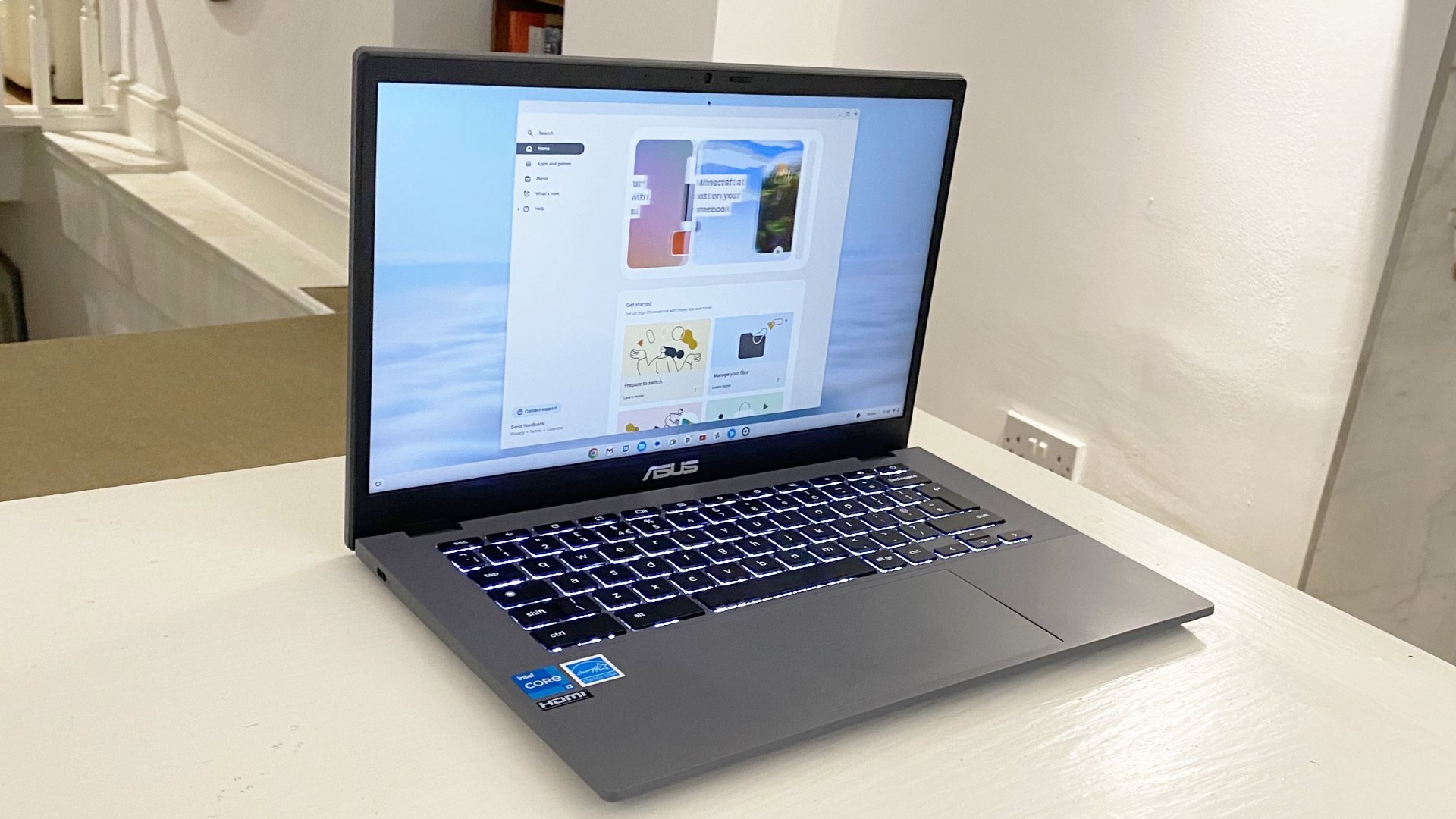 Asus Chromebook Plus laptop open with the screen on, sitting on a desk