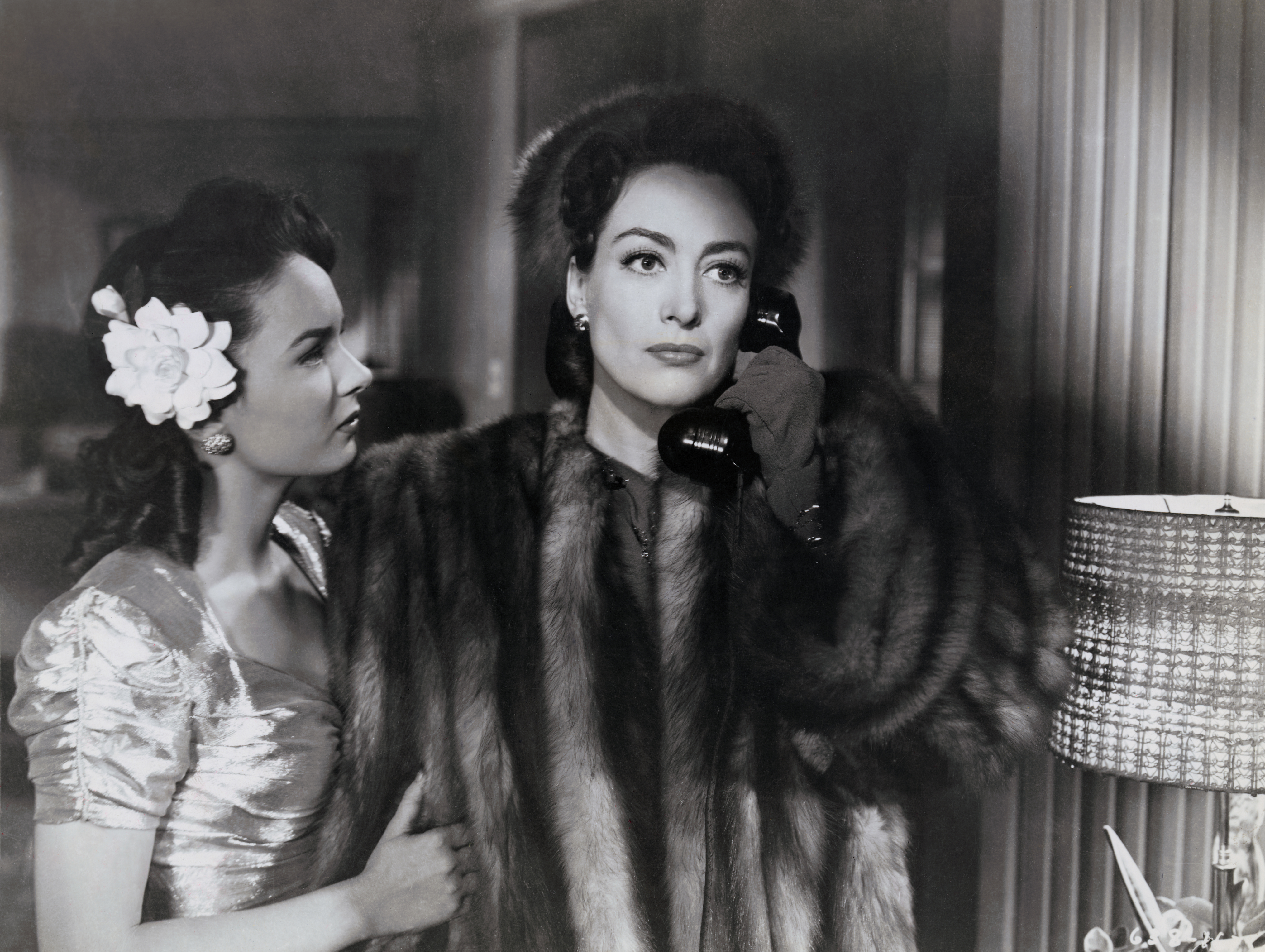 joan crawford wears a fur coat and talks on the phone in the movie mildred pierce