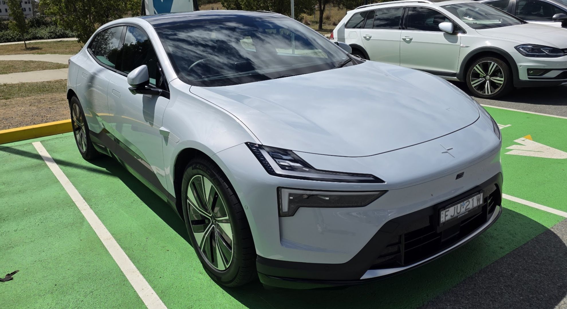 An electric car parked in a green car space