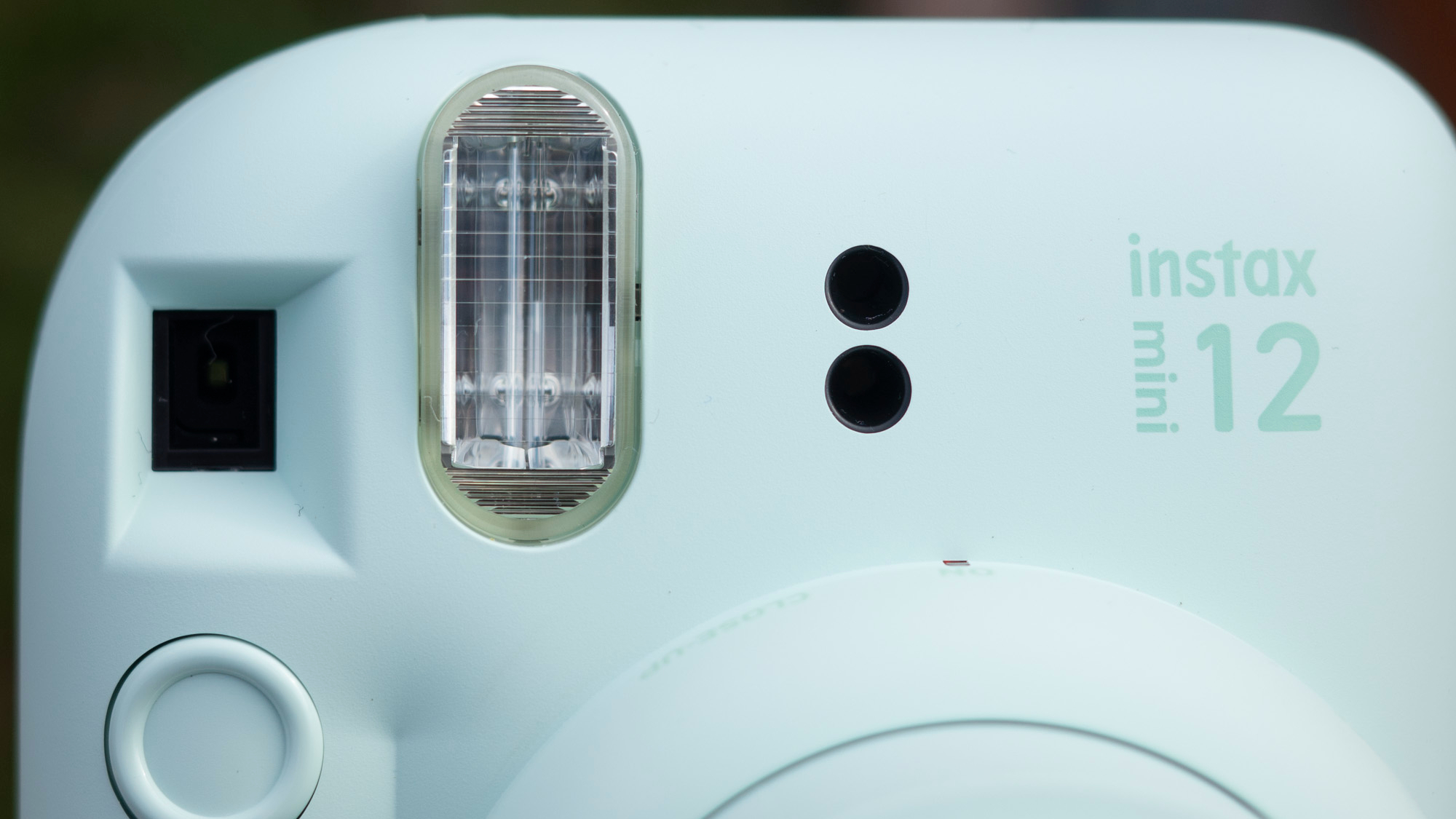 Instax Mini 12 on a brick wall in front of graffiti