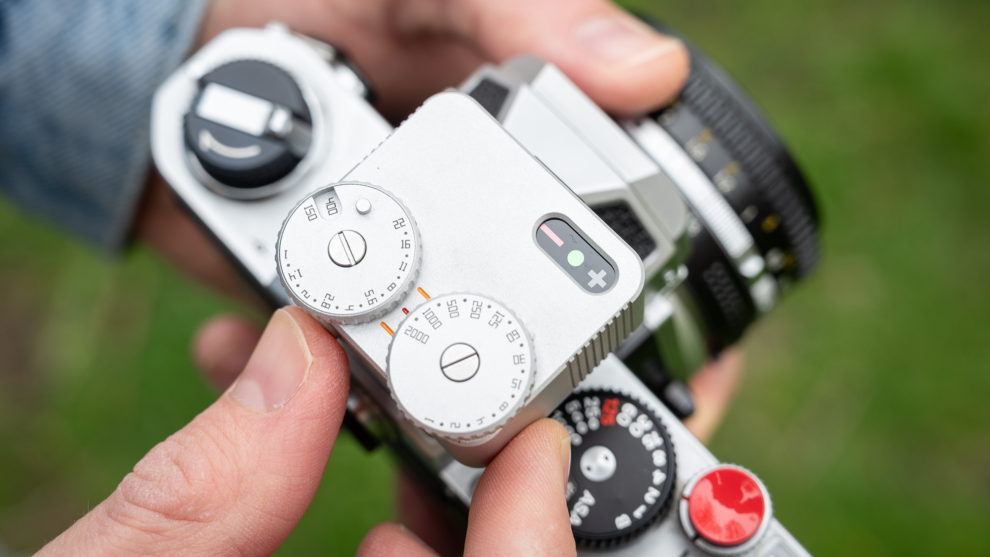 Close-up of TTArtisan Light Meter II on a Nikon FM being held out in the field 