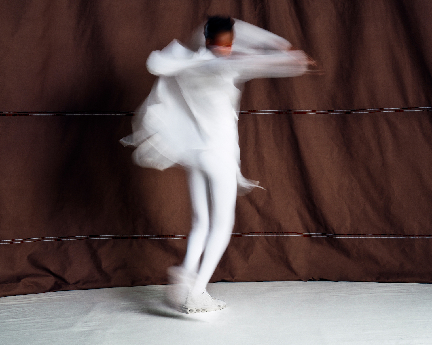 Person wearing white and matching Ferragamo sneakers