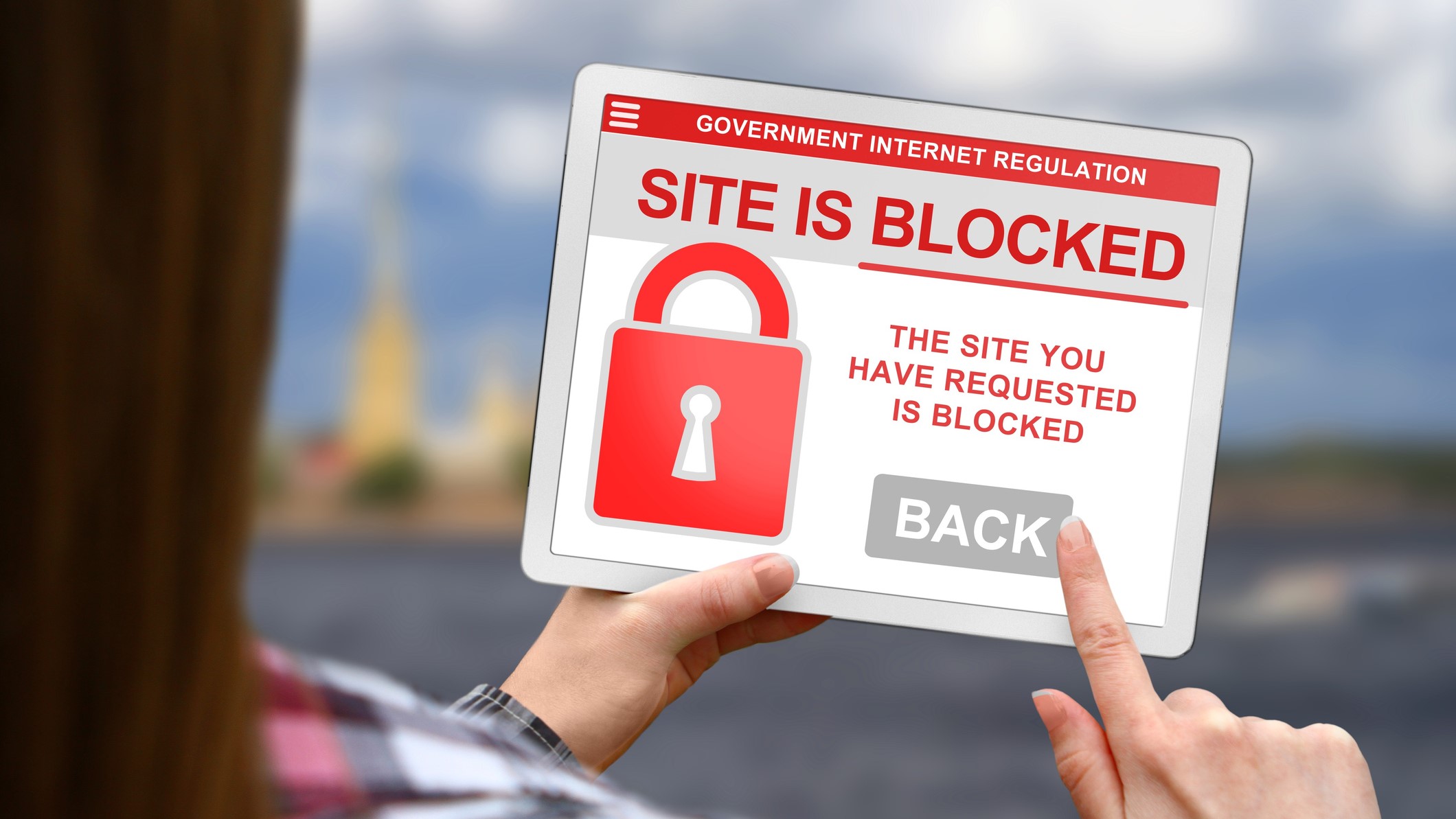 Web site blocked concept, girl holds the digital tablet on blurred clouds background