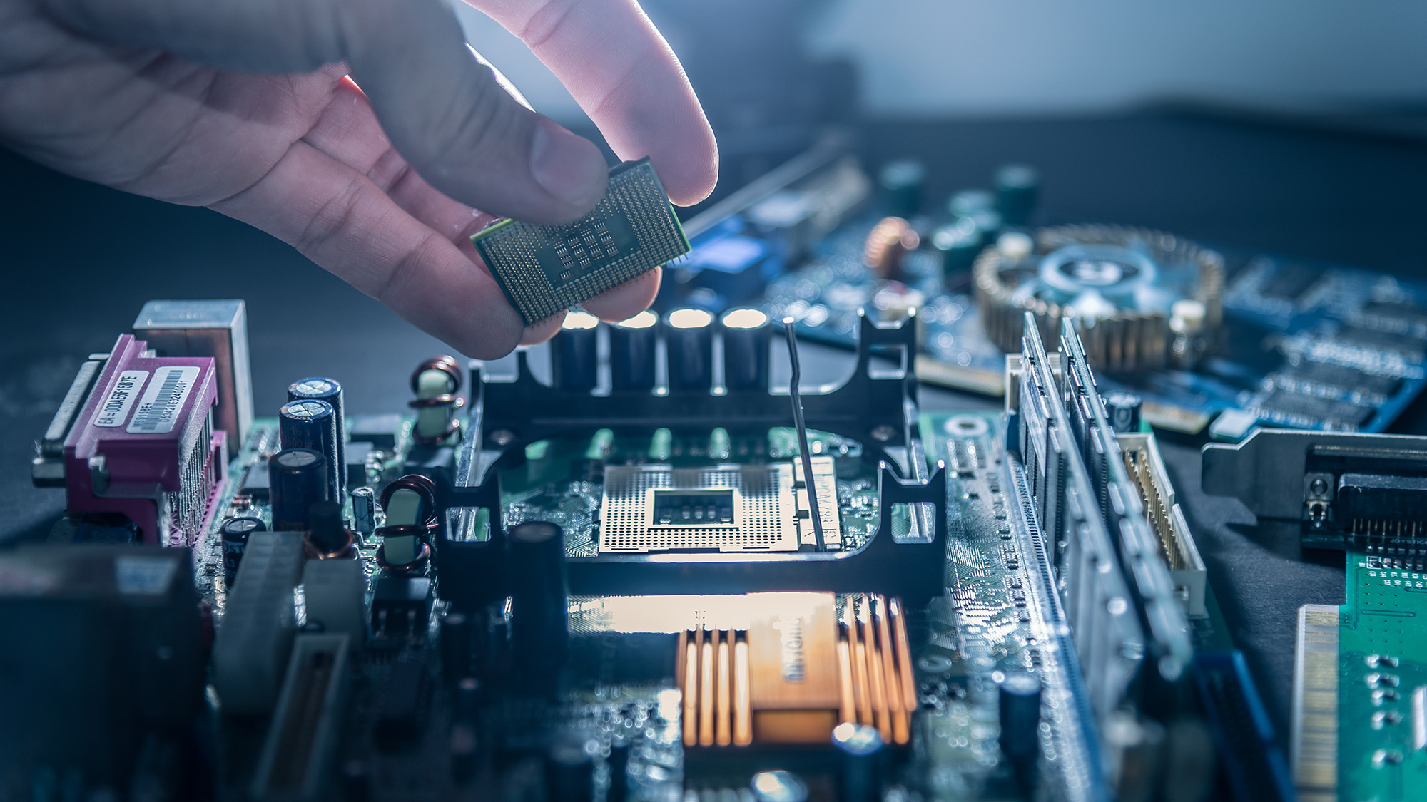 A technician putting a CPU into a socket of a computer motherboard