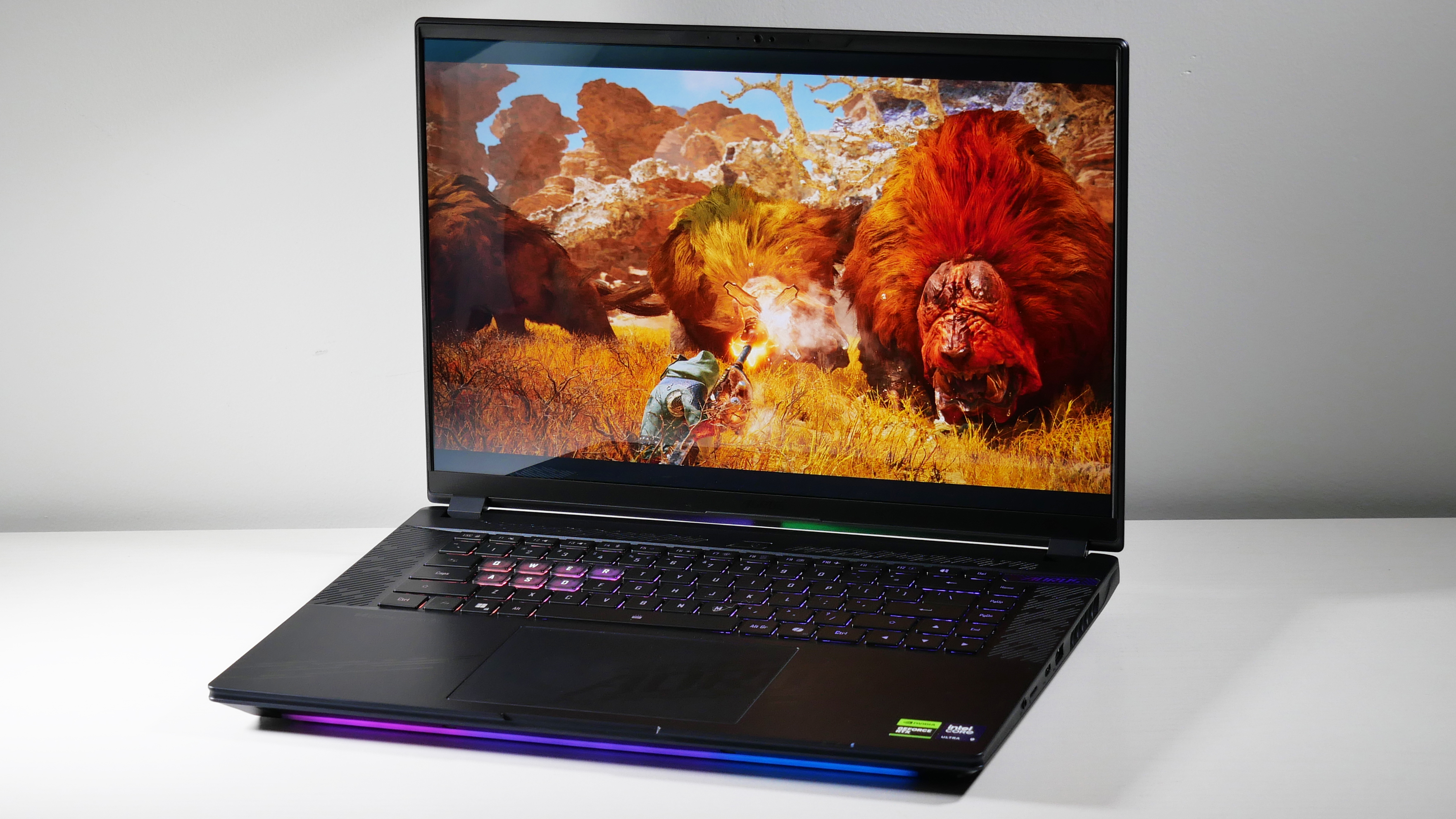 Gigabyte Aorus Master 16 (RTX 5080) opened at an angle with Monster Hunts Wilds on screen.