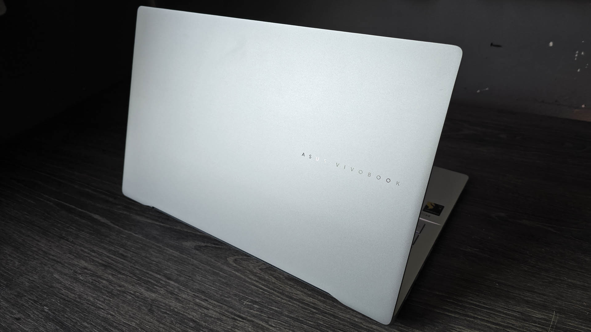 The Asus Vivobook S 15 Copilot+ in silver pictured on a wooden desk.