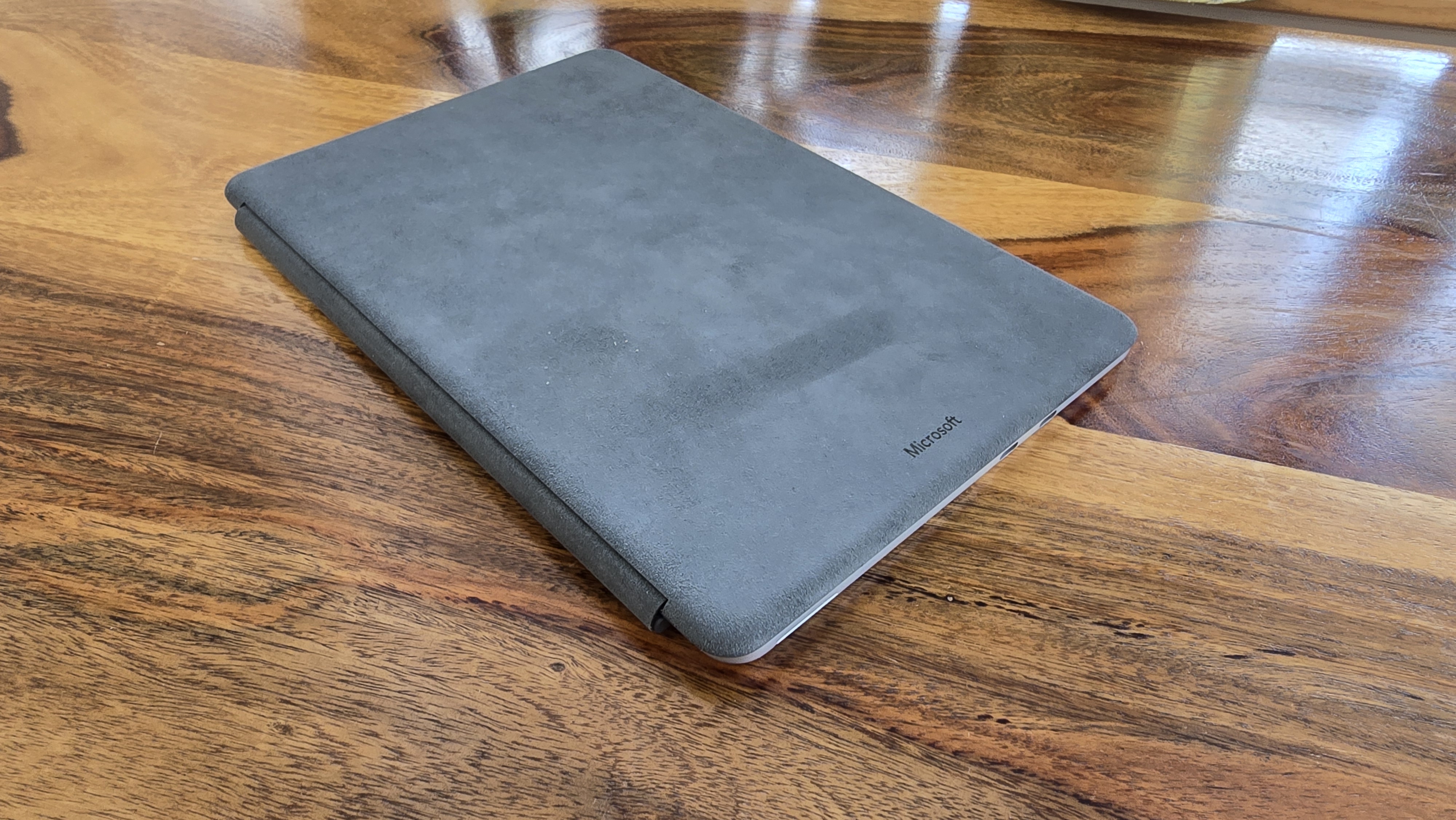 Microsoft Surface Pro 12 tablet on wooden table in relaxed cafe