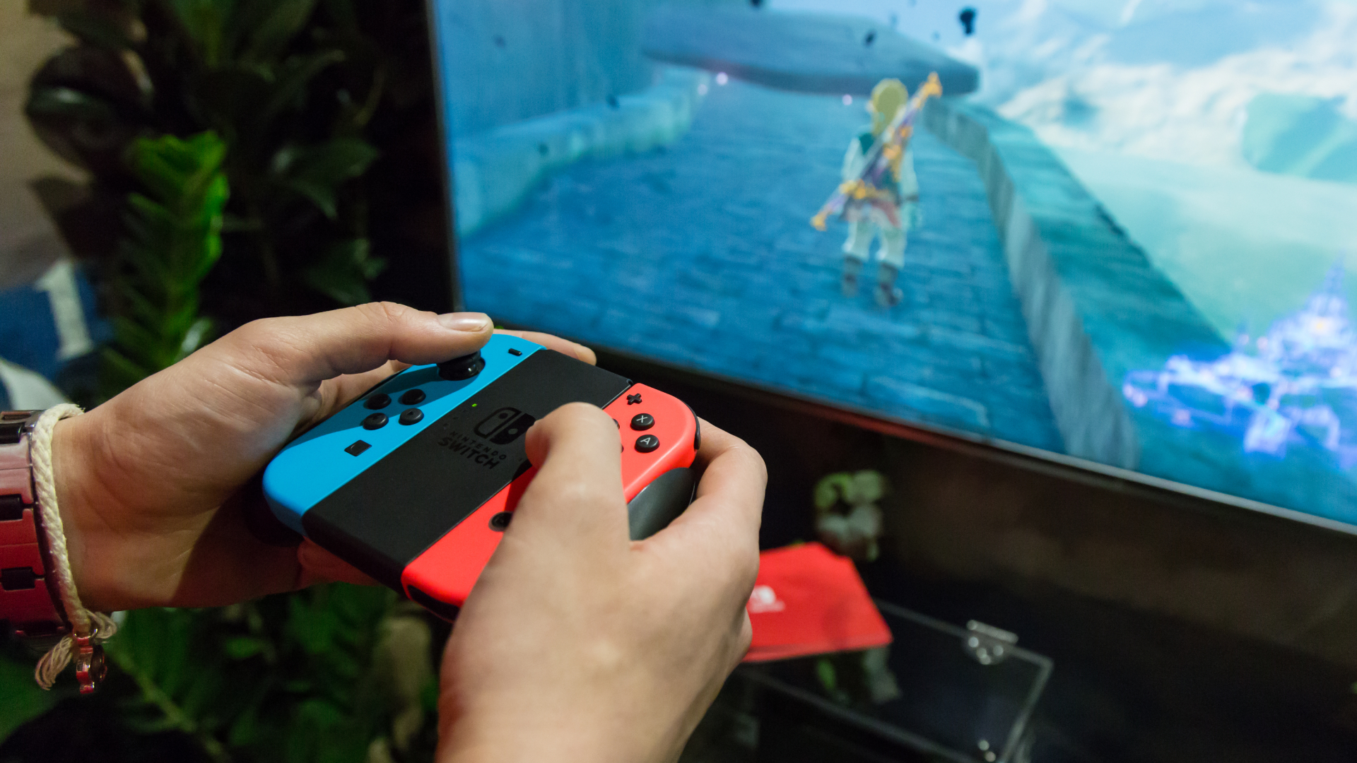 Bästa Nintendo Switch-spel: En Nintendo Switch-spelare som använder Joy-Con-kontrollerna för att spela Breath of the Wild på en TV
