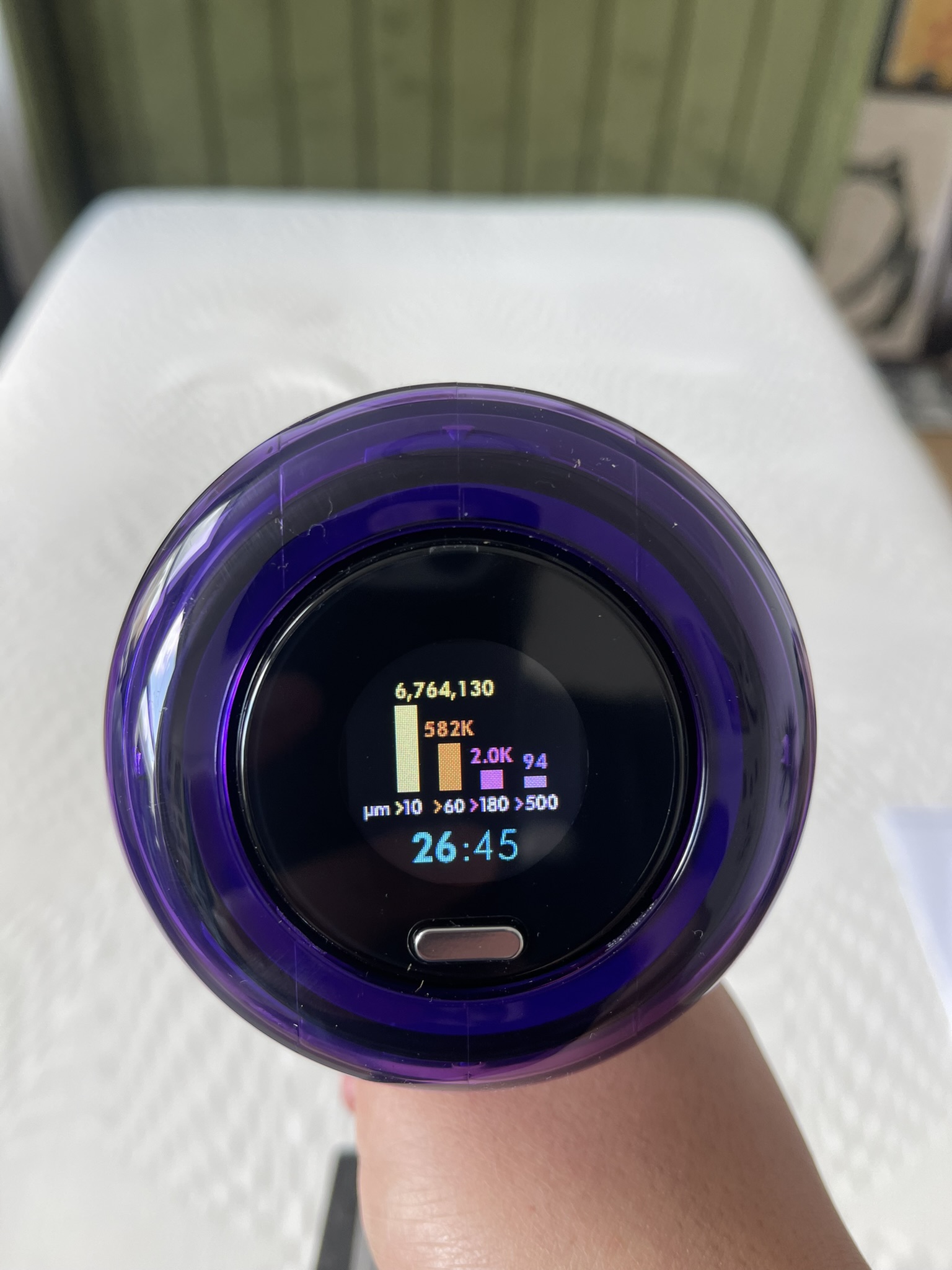 Dyson V12 Detect Slim vacuuming a mattress, displaying how many particles have been collected